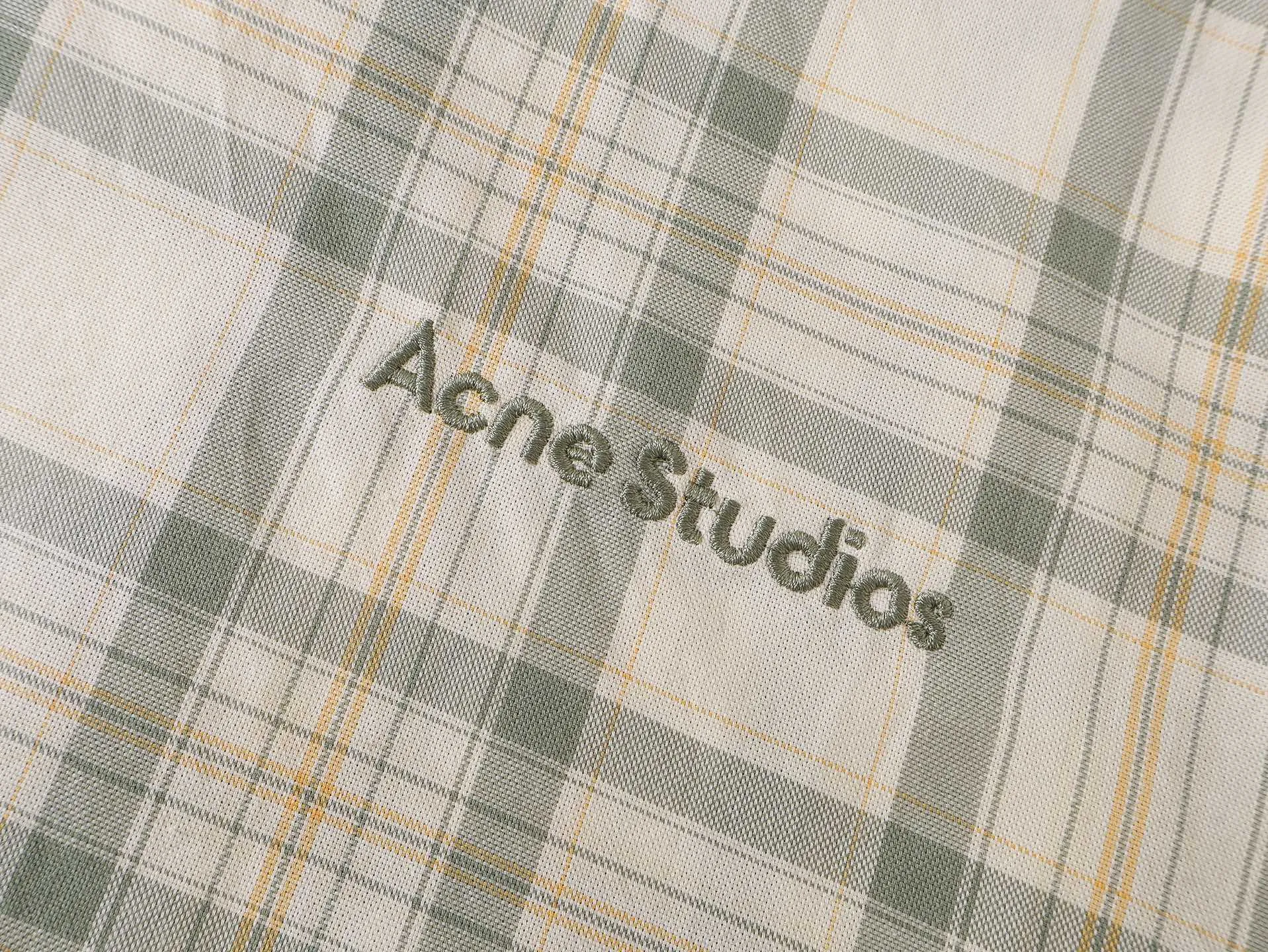 Acne Fresh Green Check Thin Jacket size 36 38 40 62 The design logic of ready-to-wear clothing is simple on the outside and complex on the inside. It superimposes multiple layers of precision weaving, three-dimensional cutting and refined finishing processes on the light fabric base. Under the seemingly simple and relaxed visual appearance, there is a multi-dimensional and high-standard ready-to-wear production system. The process chain is cumbersome and the error tolerance rate is extremely low. The fabric is made of high-count fine blended thin twill base material, and the fiber ratio has been repeatedly adjusted. On top of its lightweight, breathable and transparent spring and summer properties, it solves the industry pain points of thin materials that are easy to collapse and have no skinny feel. The fabric is dyed using a penetrating low-temperature fixation process, which is layered in three layers to fix and lock the color, allowing the fresh green blend of dark and light colors to form a soft matte gradient layer, avoiding the defects of conventional plaid fabrics such as floating color, color difference, and blooming after washing. The surface of the fabric is treated with matte softening and washing, retaining the subtle natural texture, taking into account drape and moderate stiffness. The single fabric molding goes through six basic processes of weaving, pre-shrinking, dyeing, color fixing, soft washing and shaping. The plaid pattern is not a conventional printing process. It is formed by a two-color weaving process of warp and weft. The dark Light Green yarn and the base yarn are interspersed and arranged at a fixed density. The yarn arrangement value per inch is accurately locked. The thickness of the horizontal and vertical lines of the plaid and the proportion of white space are unified and coordinated. The whole process of ready-made garments is executed with a full-width alignment process. The front, back, placket, sleeves, and hem divisions are all accurately aligned with the grain. Thin materials are weak in toughness and easy to stretch and deform. The alignment process requires low-temperature fixation throughout the entire process, and segmented positioning and sewing. A slight stretch will cause grain deviation, which greatly increases the difficulty of cutting and sewing. The version adopts a multi-piece three-dimensional cutting structure, abandoning the simple whole-piece cutting design, and deconstructing the shoulder area, body and side seams into pieces to create a relaxed and slightly wider silhouette. The arc of the dropped shoulders, the volume of the sleeves, and the closing of the hem are all fine-tuned according to the dynamic curve of the human body, taking into account the casual relaxation and the regularity of the pattern. Invisible darts are hidden at the joints of the cut pieces to optimize the fit without destroying the integrity of the appearance. During the pattern making stage, multiple sample garments need to be made to calibrate the proportions. The sewing details follow the standard of seamless high-density sewing. All joints are overlocked and overlocked with an integrated process. The stitch density is even and uniform. The cuffs and hem have hidden micro-elastic gathering structures, and the transition is smooth without bulges. The entire piece integrates complex weaving, counter-cutting, three-dimensional tailoring, and multi-layer finishing techniques, using invisible complicated techniques to support a simple appearance, fully embodying the strict and sophisticated production standards of Premium garments.